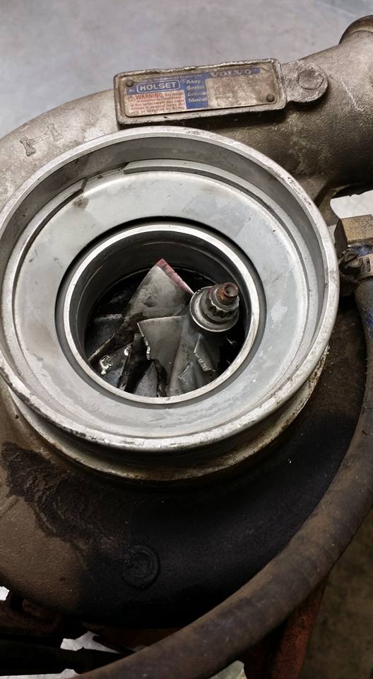 Failed Holset turbocharger components on a bench