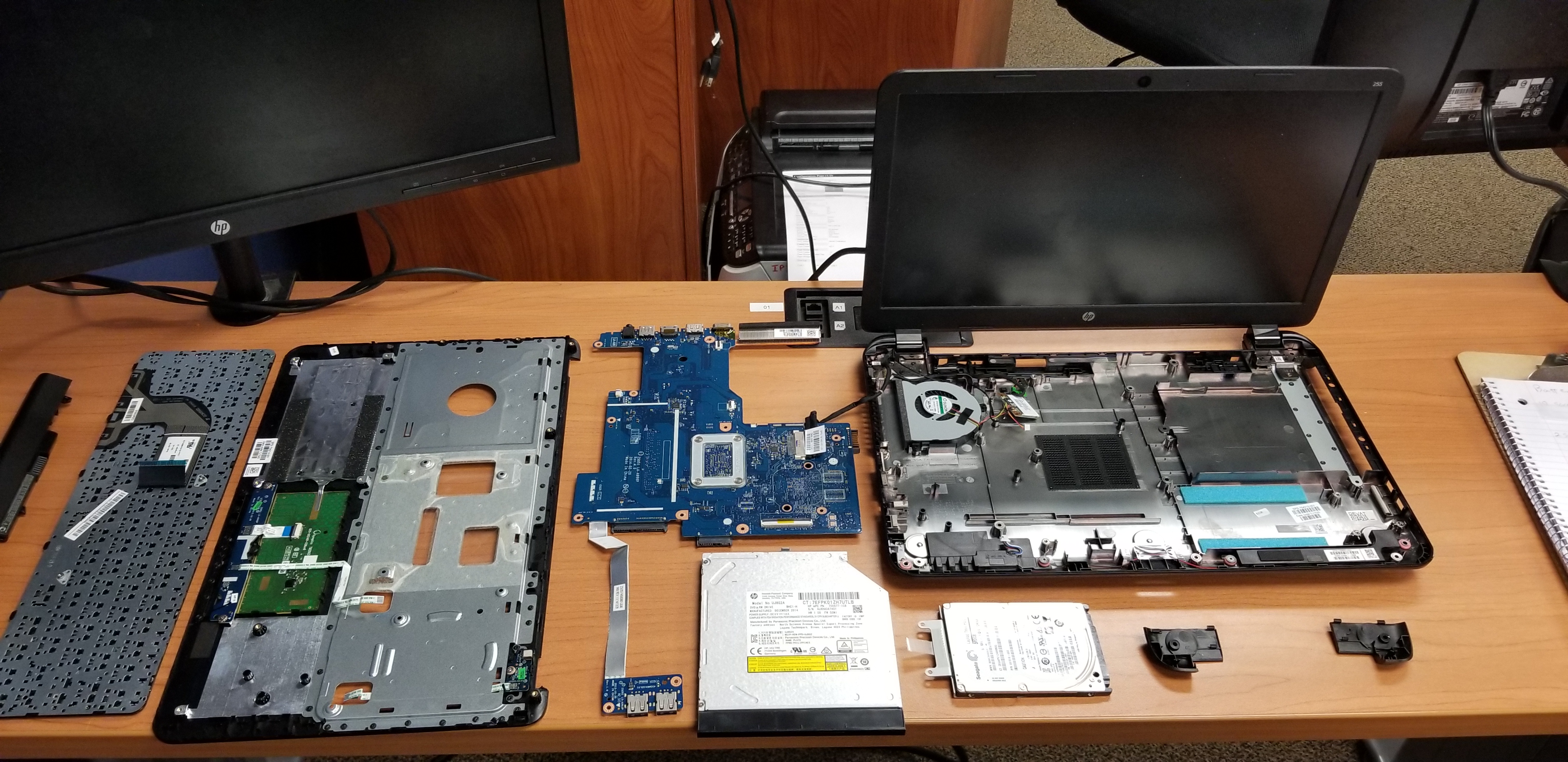 Disassembled laptop components arranged to show their system relationships.